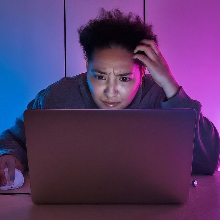 lady scratching her head while looking at her laptop